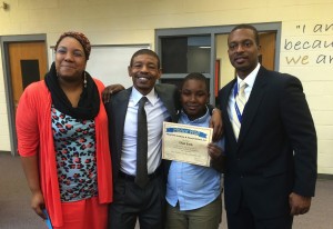 Bogues at an Honor Roll celebration with a young student and the student's parents.